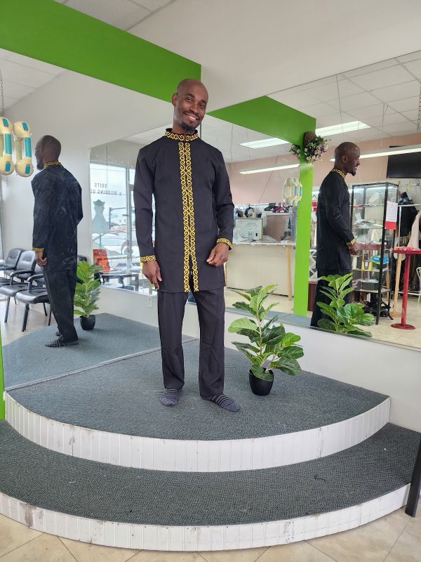 Client in a gold-embroidered suit standing on the fitting platform